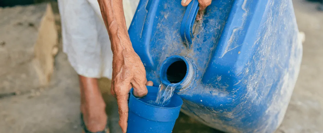 Photograph of water being decanted into a cup from a barrel
